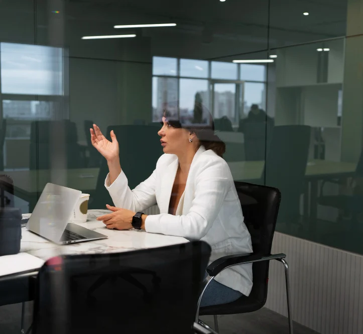Professional woman in a modern office leading a client discussion, representing Tasyier's dedicated nearshore project management and communication.